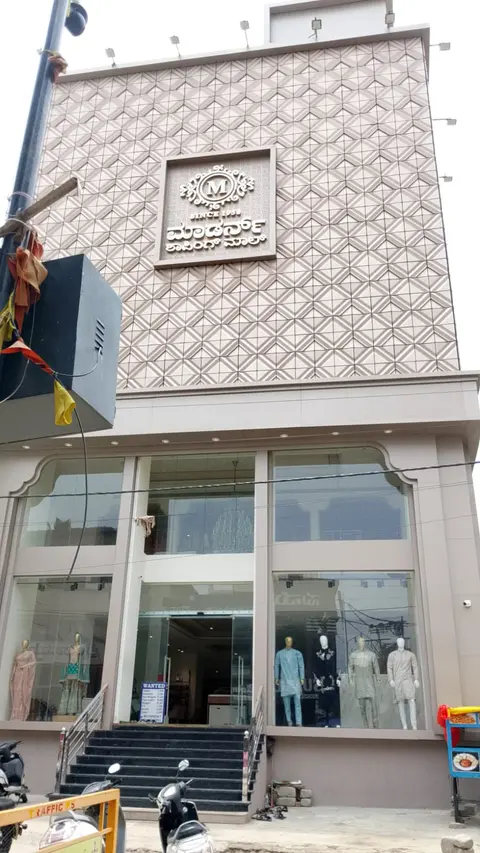 The showroom from the street: a modern white facade with a geometric patterned upper storey.